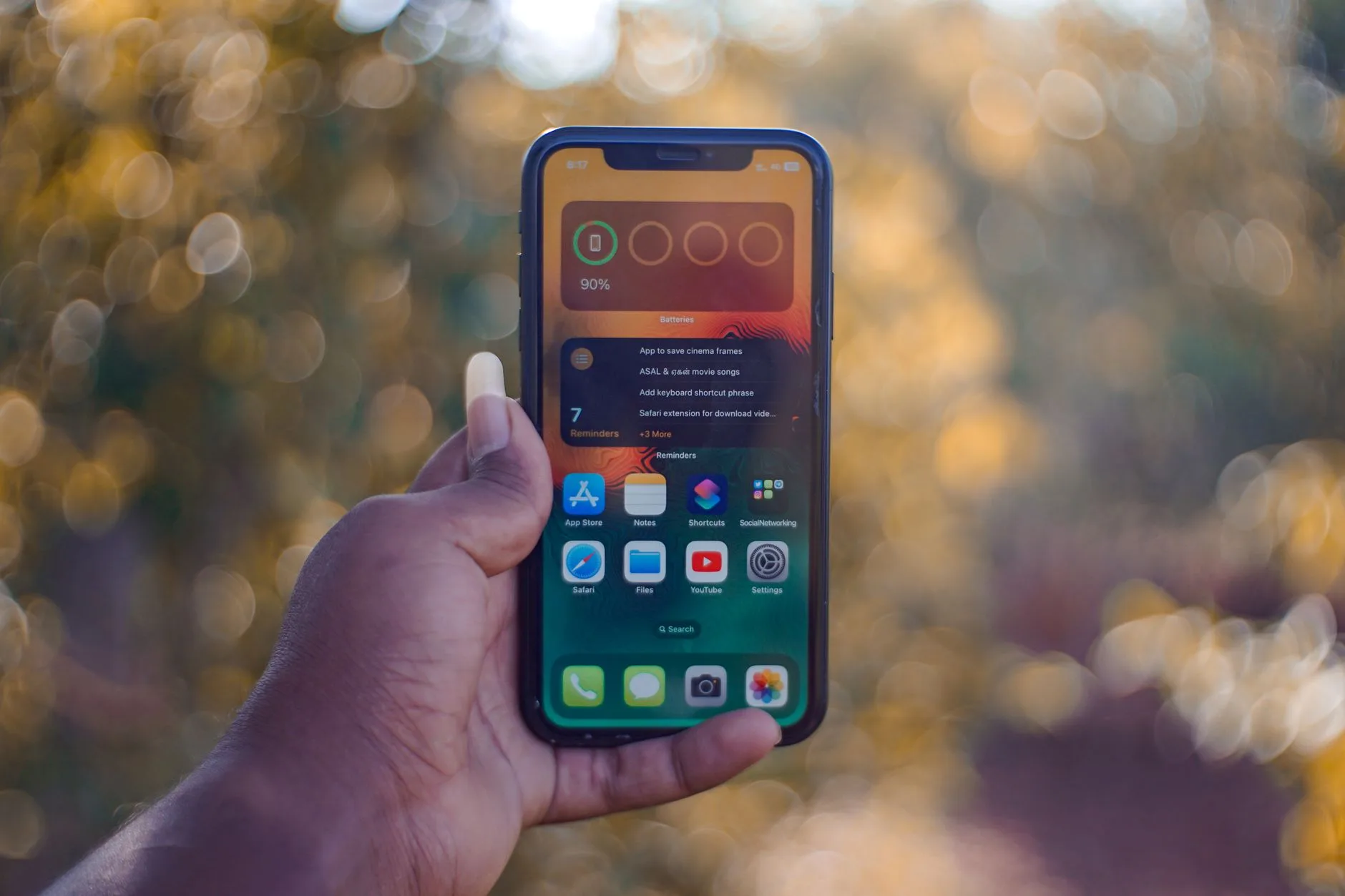 Melhores aplicativos para acompanhar hábitos diários — Imagem da mão de uma pessoa segurando um smartphone contra um fun