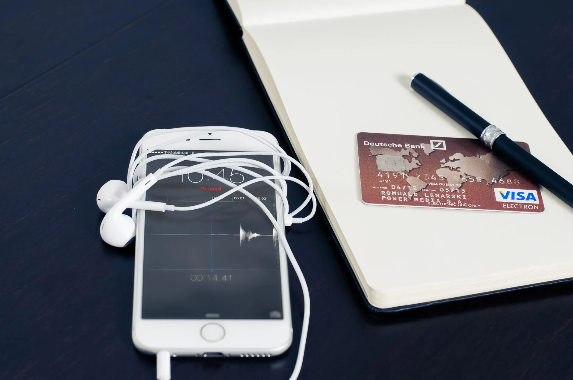 Melhores aplicativos para acompanhar hábitos diários — Um smartphone branco com fones de ouvido, cartão de crédito e can